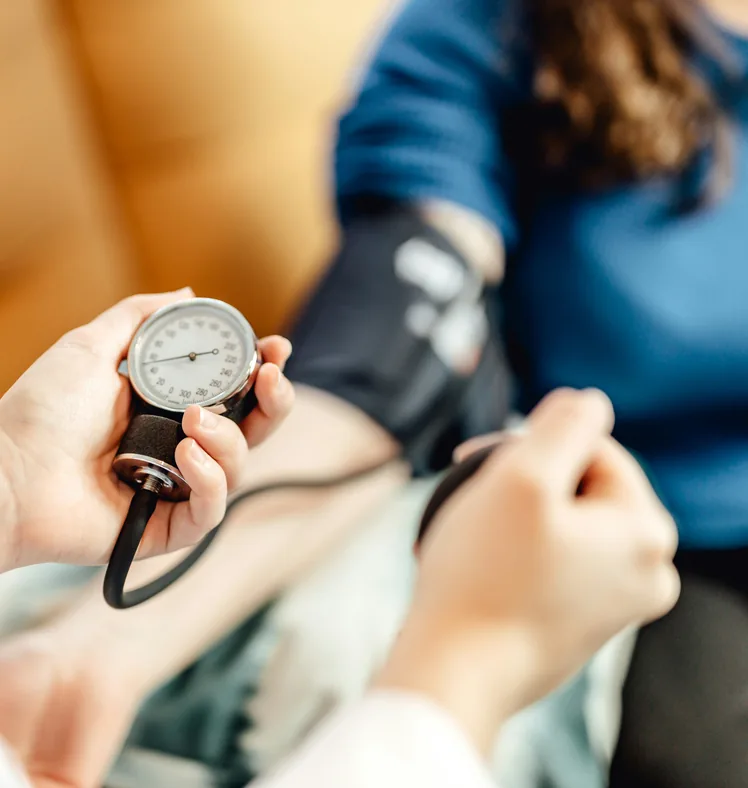 A nurse taking a patient&rsquo;s blood pressure