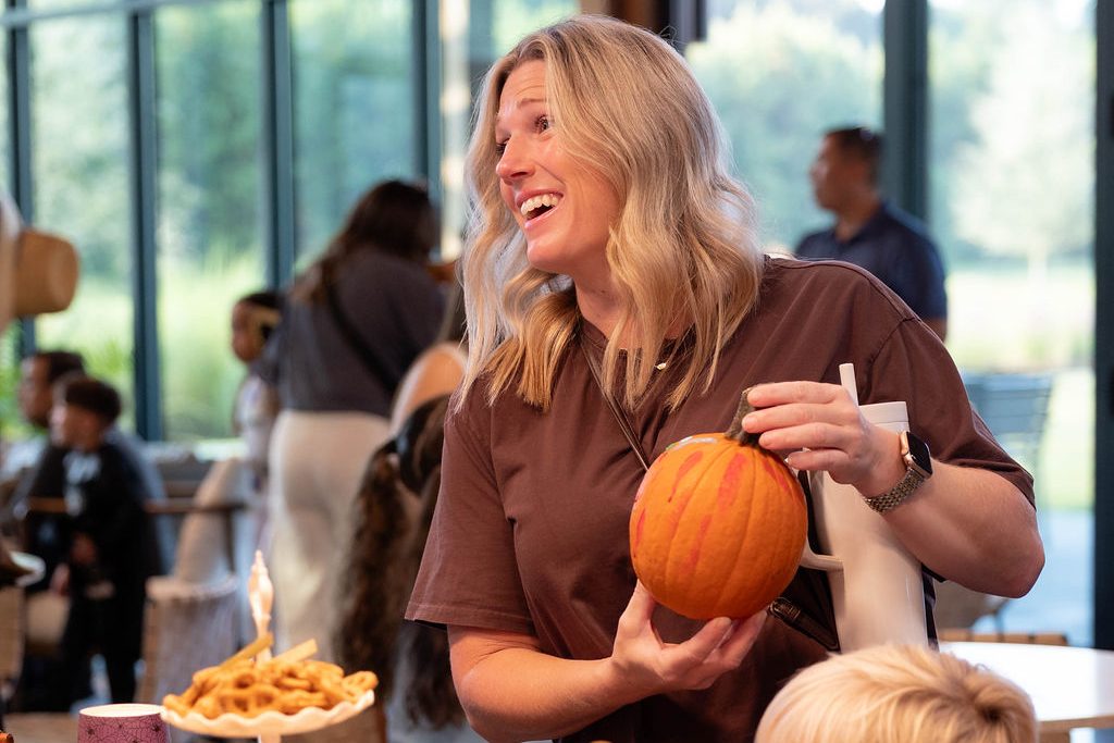 Resident laughing while holding a pumpkin Resident laughing while holding a pumpkin