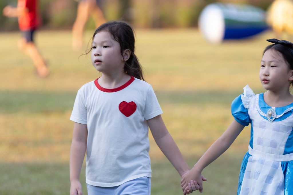 Two girls in costumes holding hands on the lawn Two girls in costumes holding hands on the lawn