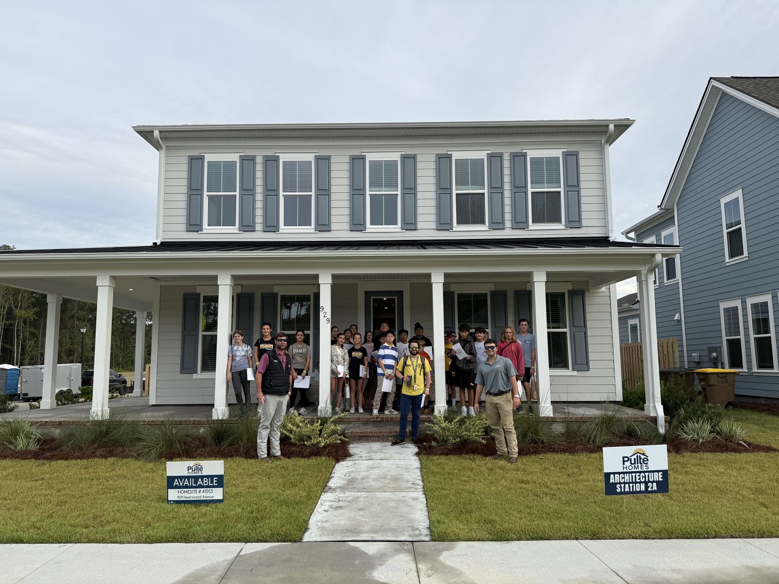 Seventh-grade STEM students and PulteGroup team members in front of a Pulte home at Heartwood